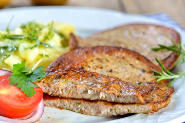 Eine bayerische Spezialität: Gebratene Milzwurst mit Kartoffelsalat - Bavarian food: Fried sausage with pieces of spleen served with potato salad