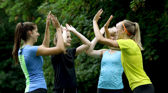 Gruppe junger Sportlerinnen beim High Five geben