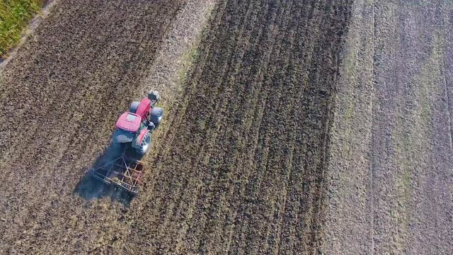 Video Clip roter Traktor in der Landwirtschaft pflügt den Acker und fährt durch das Bild