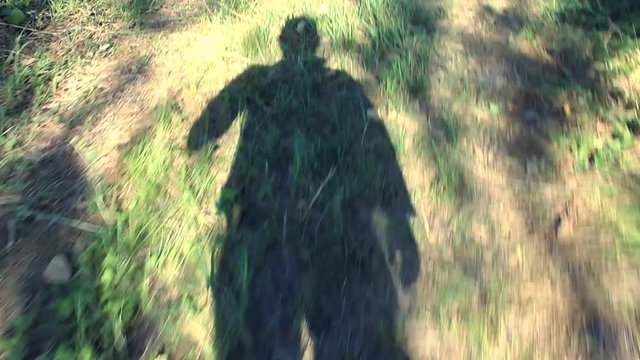 Shadow man walking on the grass