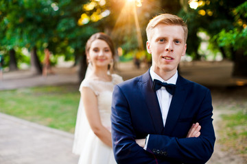 Handsome groom and pretty bride in the park