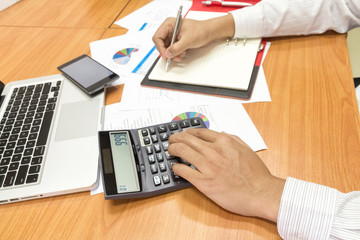 Fototapeta na wymiar Businessman using calculator for working on his plan project