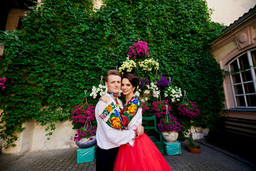 Happy wedding couple among city colorful flowers