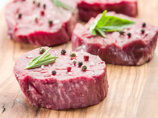 Pieces of beef tenderloin on the wooden cutting board.