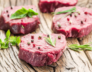 Pieces of beef tenderloin on the wooden cutting board.