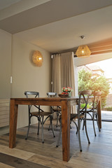 salle à manger avec porte-fenêtre ouverte sur le jardin