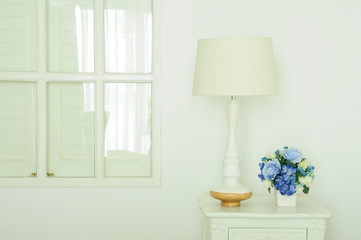 Vintage lamp and artificial bouquet on white small desk, Home de