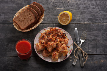 chicken a barbecue, bread, lemon and tomato juice on a wooden table