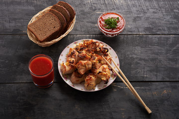 shish kebab in the plate, Chinese sticks sauce and bread on a on a wooden table