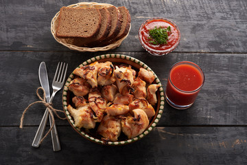 shish kebab in the plate, sauce and bread on a wooden table