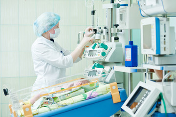 Fototapeta premium intensive care unit female doctor with baby infant