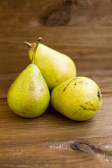 Some yellow pears are on the wooden table