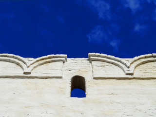 Fototapeta na wymiar Brick wall with battlement against the sky background