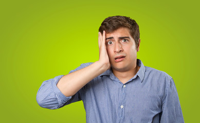 Close up of a worried young man on green background