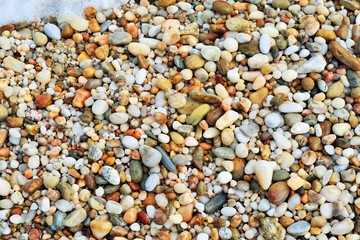 Beach pebbles form gradually over time as the sea water washes over loose rock particles