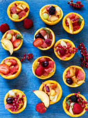 Bright fresh fruit tartes in orange rinds