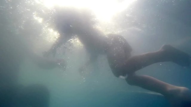 Father and young son swimming in the pool 