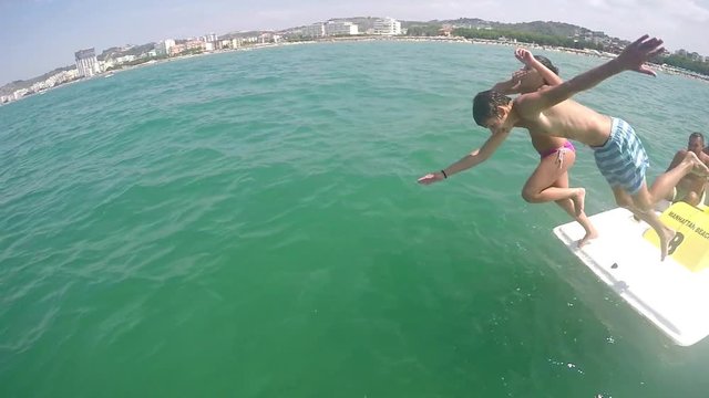 Boy, girl couple jump in the water from 