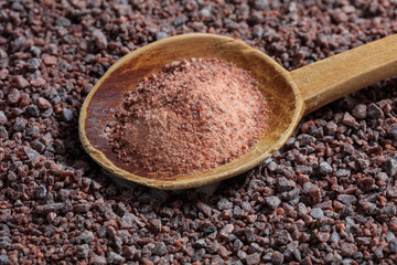 Wooden spoon on black indian salt background