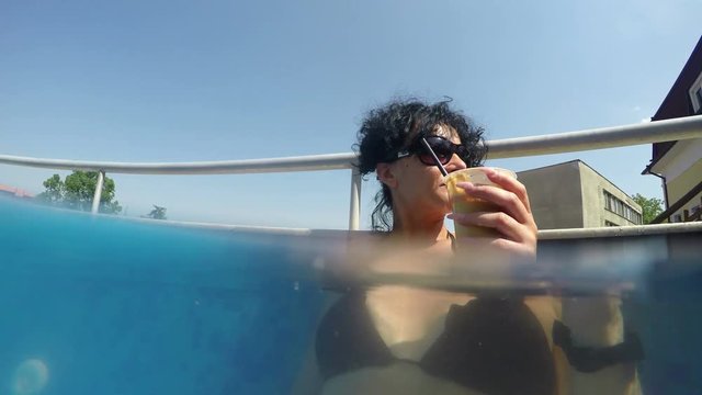 Pretty female model drinks caffee in thermal pool