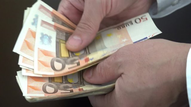 person counts the euro money bills