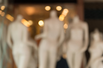 De focused/Blur image of boutique window with dressed mannequins. Boutique display window with mannequins in fashionable dresses. Toned image.