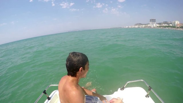 Boy swim and jump on yacht boat back