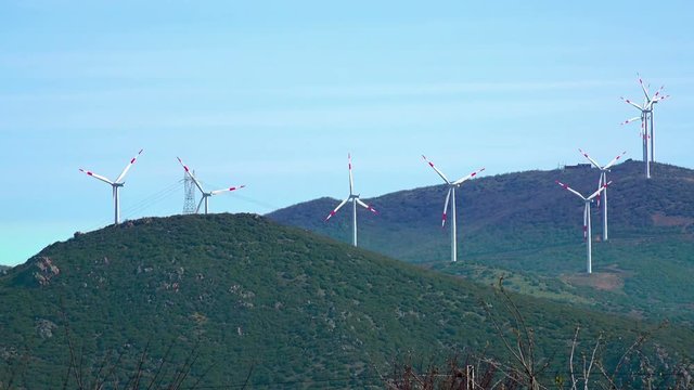 Row of wind power generators on mountain hills, 