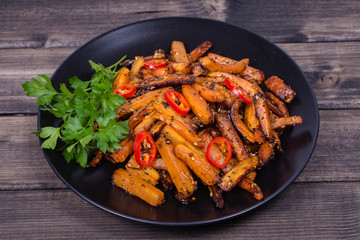 Roasted carrots in black plate, close up