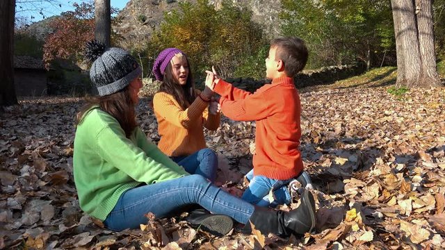 Children play game in the autumn forest sitting,  steadicam shot