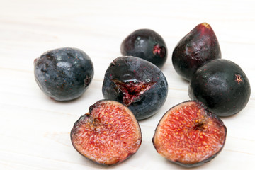 Ripe figs on the white wood background