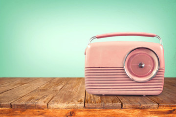Retro radio on table with vintage green eye light background - old technology