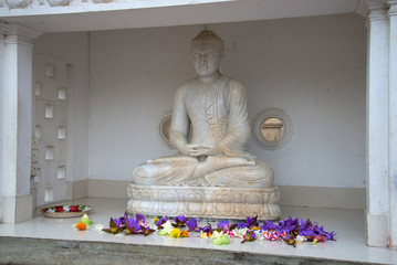 Ancient marble sculpture of a seated Buddha at the foot of the Dagoba Ruvanvelisaya