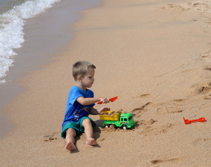 little boy playing with beach