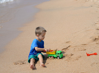 little boy playing with beach