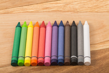 The colorful crayon on the wooden background