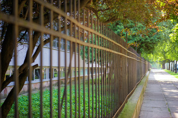 Fototapeta na wymiar Perspective. Fence on the street.