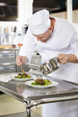 Obraz na płótnie Canvas Professional chef prepare meat dish at restaurant