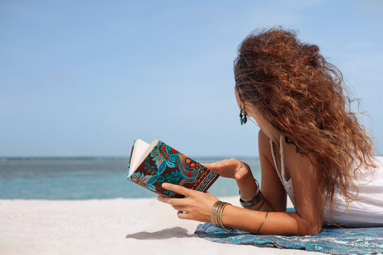 Beautiful Young Woman Reading Book On Beach