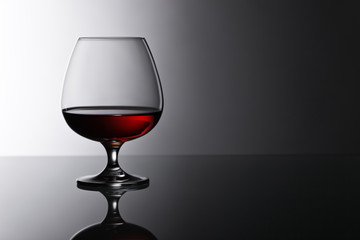 snifter of brandy on glass table