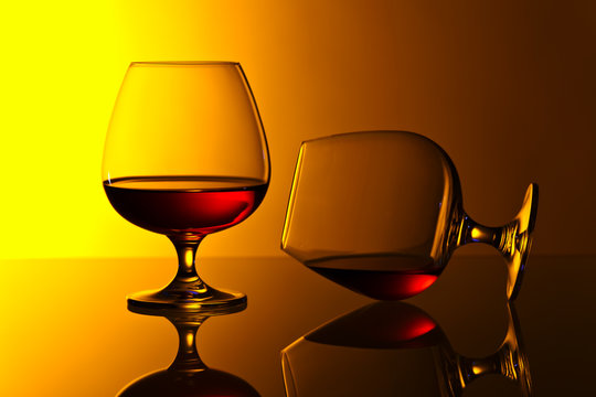 Two snifters of brandy on glass table