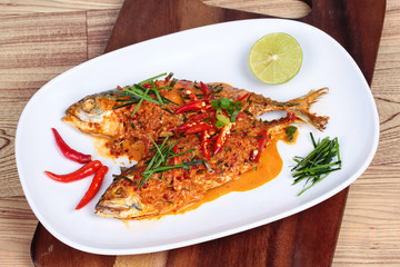 Mackerel fish fried topped spicy curry  on wood 