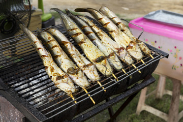 Marinate catfish on the grill at the market in Thailand