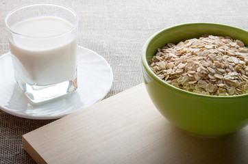 Green bowl of dry cereal on a wooden board