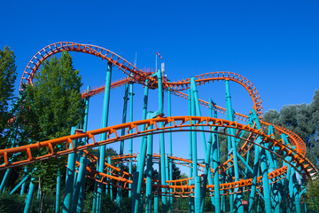 Orange rollercoaster with blue sky in the background
