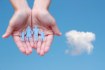 Paper family in hands on blue sky background welfare concept
