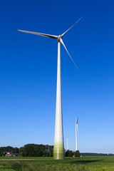 Wind turbine spinning with in a green countryside environment