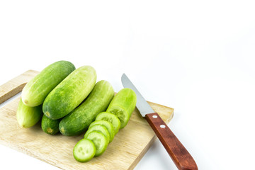 Cucumber slices on cutting board on white background