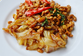 fried large noodle and spicy chop pork with basil leaf on dish