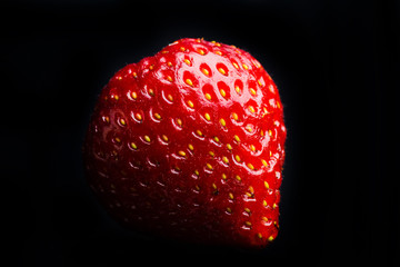 Strawberry isolated on black background. Shallow depth of field. © maxandrew